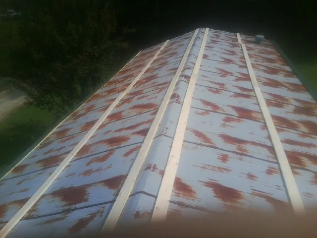 Rusted metal roof panels with new wood purlins before replacement — Storm Damage Roof Repair in National Park by Roofing Brothers